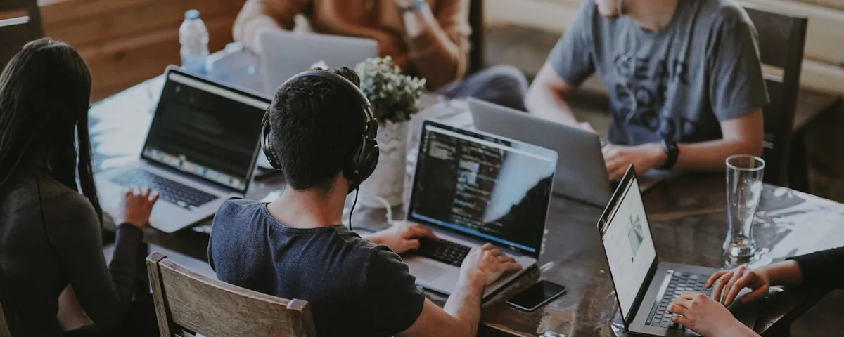LeafyCode team collaborating at a shared workspace — by Annie Spratt on Unsplash